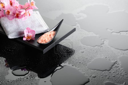 Téléchargez les photos : Belle floraison fleurs d'orchidée et rose sel de mer. Fond réfléchissant noir avec gouttes d'eau. - en image libre de droit