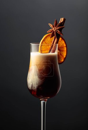 Photo for White Russian cocktail garnished with cinnamon, anise, and dried orange slice. - Royalty Free Image