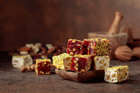 Photo for Traditional Turkish delight on an old brown table with wooden kitchen utensils. - Royalty Free Image