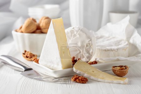 Photo for Camembert cheese with walnuts on a white wooden table. - Royalty Free Image
