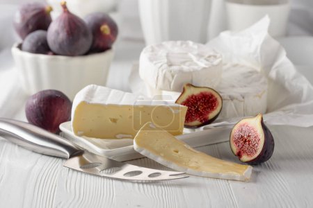 Photo for Camembert cheese with figs on a white wooden table. - Royalty Free Image