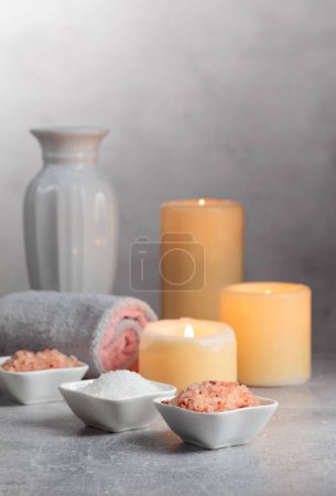 Foto de Sal marina, toallas y velas encendidas sobre un fondo gris. Concepto de spa con espacio para copiar. - Imagen libre de derechos
