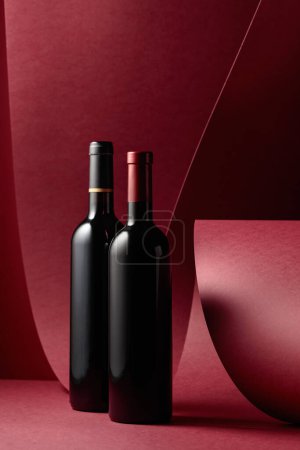Foto de Botellas de vino tinto sobre fondo tinto. Copiar espacio. - Imagen libre de derechos