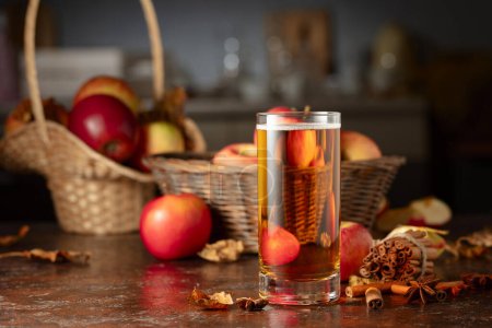 Foto de Jugo de manzana con manzanas frescas, canela y anís en una mesa de cocina. - Imagen libre de derechos