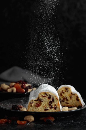 Photo for Traditional fruit cake with raisins and nuts sprinkled with sugar powder. - Royalty Free Image