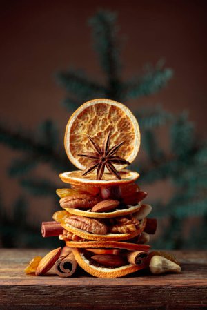 Téléchargez les photos : Fruits secs et noix sur une vieille table en bois. Nature morte de Noël avec branches d'épinette. - en image libre de droit