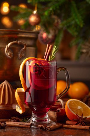 Photo for Mulled wine with citrus, cinnamon, anise, and rosemary. Christmas mulled wine with spices, citrus, and vintage kitchen utensils. - Royalty Free Image