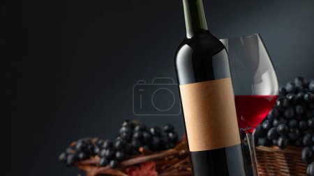 Photo for Bottle and glass of red wine with blue grapes. On a bottle old empty label. Selective focus. - Royalty Free Image