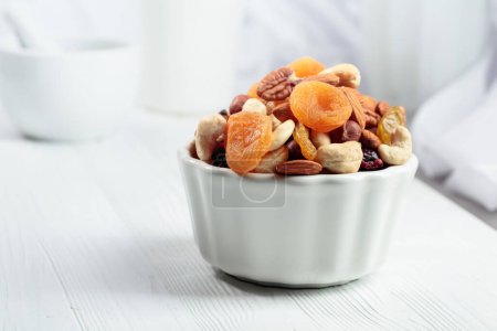 Photo for Dried fruits and assorted nuts on a white wooden table. - Royalty Free Image