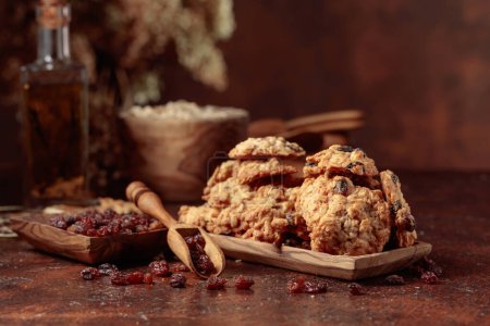 Photo for Oatmeal raisin cookies and kitchen utensils on a brown table. Copy space. - Royalty Free Image