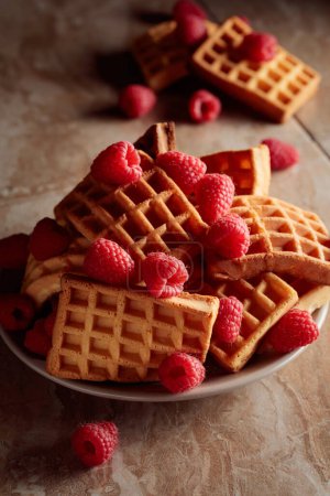 Photo for Belgian waffles with raspberries on a brown ceramic table. - Royalty Free Image
