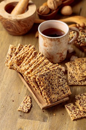 Téléchargez les photos : Crispy crackers with sunflower seeds and flax seeds on a wooden table. - en image libre de droit