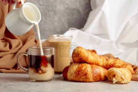 Photo for Croissants and coffee with cream. Pouring creme in a glass cup of coffee. - Royalty Free Image