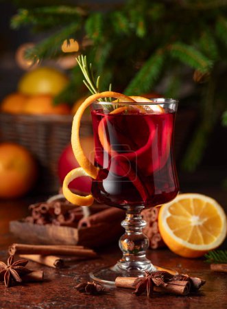Photo for Hot mulled wine with citrus, cinnamon, anise, and rosemary. Christmas mulled red wine with spices and fruits on a brown rustic table. Traditional hot drink at Christmas time. - Royalty Free Image