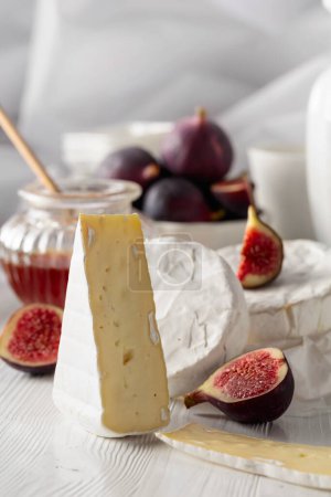 Photo for Camembert cheese with figs and honey on a white wooden table. - Royalty Free Image
