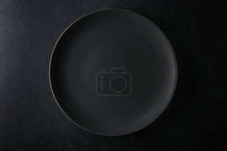 Foto de Placa negra vacía en una mesa de piedra negra. Vista superior, espacio de copia. - Imagen libre de derechos