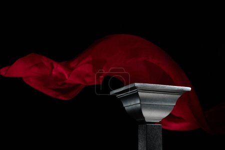 Foto de Lujoso podio negro sobre un fondo de ondulante cortina de atlas rojo. Plataforma perfecta para mostrar sus productos sobre un fondo oscuro. - Imagen libre de derechos