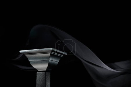 Téléchargez les photos : Podium noir de luxe sur fond de rideau de soie noir agitant. Plateforme parfaite pour afficher vos produits sur un fond sombre. - en image libre de droit