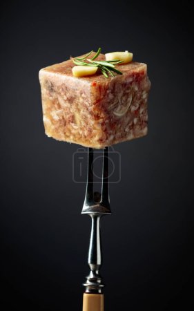 Photo for Headcheese with garlic and rosemary on a fork. - Royalty Free Image