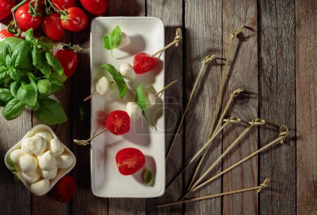 Photo for Mozzarella with basil and tomatoes on an old wooden table. Top view. - Royalty Free Image
