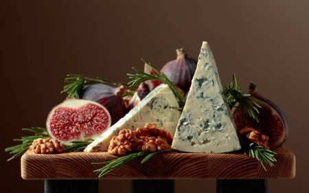 Photo for Blue cheese with figs, walnuts, and rosemary on a wooden table. - Royalty Free Image