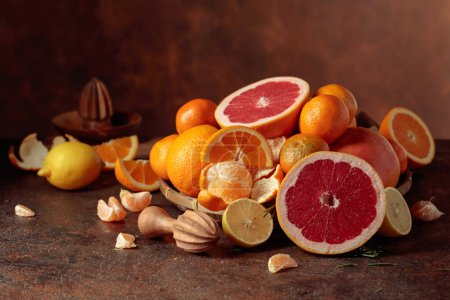 Téléchargez les photos : Agrumes sur une vieille table brune. Les oranges, pamplemousses, citrons et mandarines sont présentés. - en image libre de droit