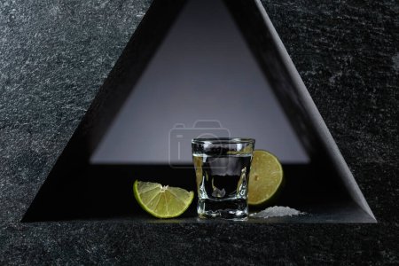 Téléchargez les photos : Tequila mexicaine au citron vert et sel de mer, fond noir. - en image libre de droit