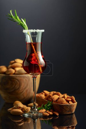 Téléchargez les photos : Forte liqueur italienne alcoolique Amaretto aux amandes noix sur fond noir. - en image libre de droit