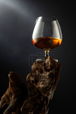 Foto de Francotirador de brandy en un viejo enganche de madera. Fondo negro con espacio de copia. Enfoque selectivo. - Imagen libre de derechos