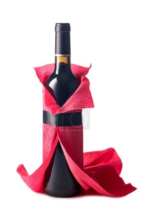 Photo for Bottle of red wine wrapped in crepe paper isolated on a white background. The bottle looks like a woman in a red evening dress. - Royalty Free Image