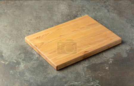 Photo for Cutting board on a stone table. Culinary background. Empty wooden cutting board, product display space. - Royalty Free Image