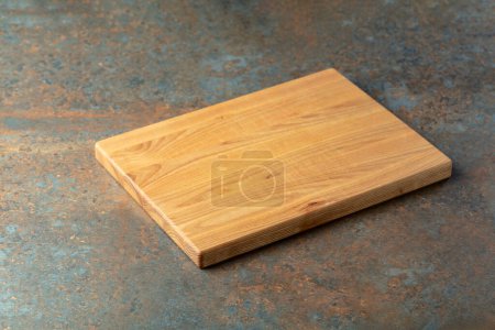 Téléchargez les photos : Planche à découper sur une table en fer rouillé. Fond culinaire. Planche à découper en bois vide, espace d'affichage des produits. - en image libre de droit