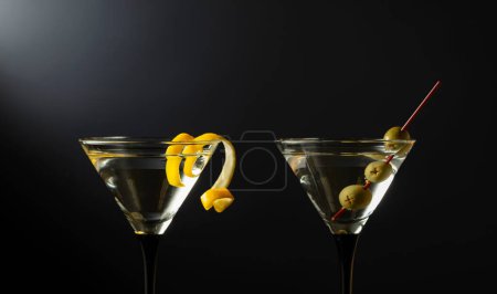 Photo for Classic dry martini cocktails with green olives and lemon peel on a black background. Free space for your text. - Royalty Free Image