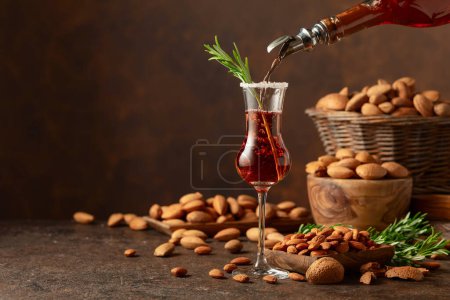 Téléchargez les photos : Forte liqueur italienne alcoolique Amaretto aux amandes noix sur une table de cuisson. Espace de copie. - en image libre de droit