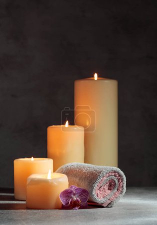 Foto de Toallas, orquídeas y velas encendidas. Concepto de spa con espacio para copiar. - Imagen libre de derechos