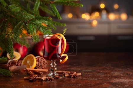 Téléchargez les photos : Vin chaud chaud chaud avec agrumes, cannelle, anis et romarin. Vin rouge chaud de Noël avec des épices et des fruits sur une table rustique brune. Boisson chaude traditionnelle à Noël. - en image libre de droit