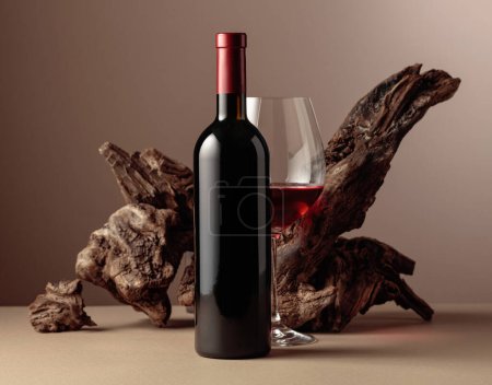 Foto de Botella y copa de vino tinto con viejo enganche envejecido sobre un fondo beige. Vista frontal con espacio de copia. - Imagen libre de derechos