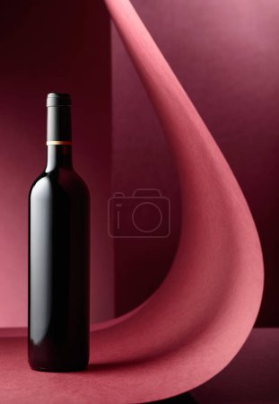 Photo for Bottle of red wine on a red background. Copy space - Royalty Free Image