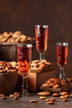 Photo for Italian liqueur Amaretto with almonds nuts on a brown background. - Royalty Free Image