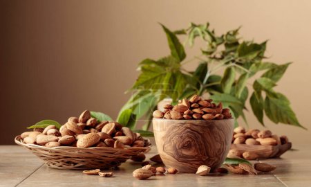 Photo for Almond nuts in wooden dishes on a ceramic table. Brown background with copy space. - Royalty Free Image