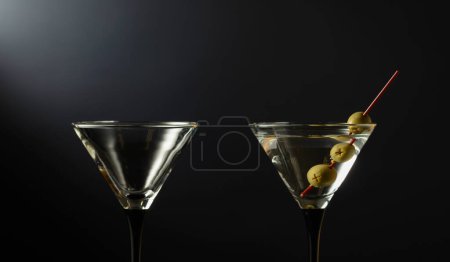 Photo for Classic dry martini cocktail with green olives on a black background. Free space for your text. - Royalty Free Image