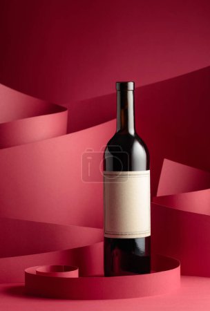 Photo for Bottle of red wine with old empty label on a red background. Copy space. - Royalty Free Image