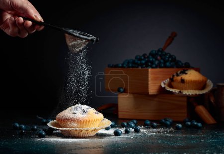 Photo for Blueberry muffins and berries in a wooden box. Muffins sprinkled with sugar powder. - Royalty Free Image