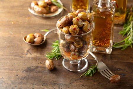 Téléchargez les photos : Olives épicées et bouteilles d'huile d'olive. Olives conservées, bouteilles d'huile d'olive et brindilles de romarin sur une table en bois. - en image libre de droit