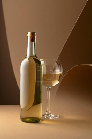 Téléchargez les photos : Bottle and glass of white wine on a beige background. Copy space. - en image libre de droit