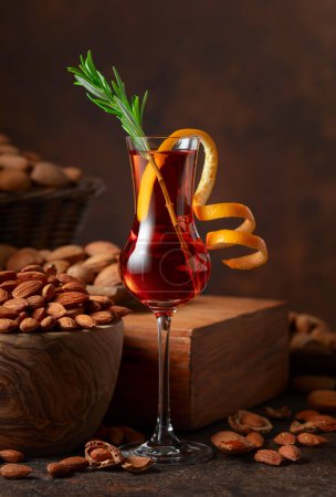 Téléchargez les photos : Liqueur italienne Amaretto garnie de brindilles de romarin et de zeste d'orange. - en image libre de droit