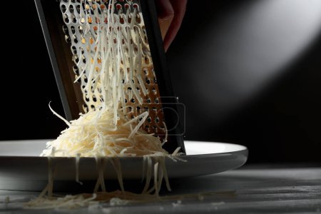 Foto de Queso rallado y rallador. Concepto: cocina italiana, queso, restaurante y comida. Copiar espacio. - Imagen libre de derechos