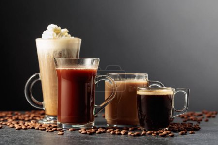 Téléchargez les photos : Diverses boissons au café et au chocolat avec des grains de café éparpillés sur une table noire. - en image libre de droit