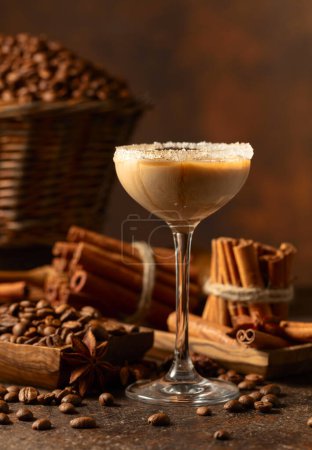 Téléchargez les photos : Crème irlandaise et liqueur de café sur fond brun. Des grains de café, des bâtonnets de cannelle et de l'anis sont éparpillés sur la table. - en image libre de droit