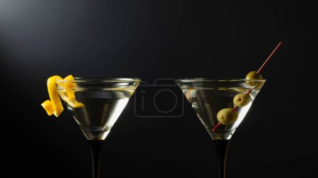 Téléchargez les photos : Cocktail martini sec classique aux olives vertes et écorce de citron sur fond noir. Espace libre pour votre texte. - en image libre de droit